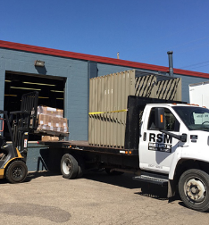 RSM flatbed truck being loaded with door frames by forklift