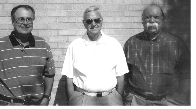 The three founders of RSM Builders Supply standing in front of a brick wall