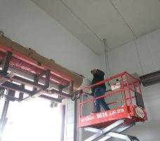 RSM installer working from a scissor lift on an overhead door opening